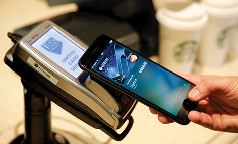 FILE PHOTO: A man uses an iPhone 7 smartphone to demonstrate the mobile payment service Apple Pay at a cafe in Moscow, Russia, October 3, 2016.    REUTERS/Maxim Zmeyev